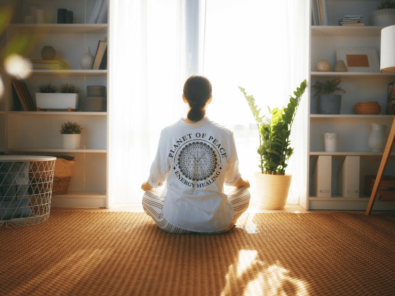 A woman releasing grief through guided meditation and energy healing with golden light surrounding her heart.