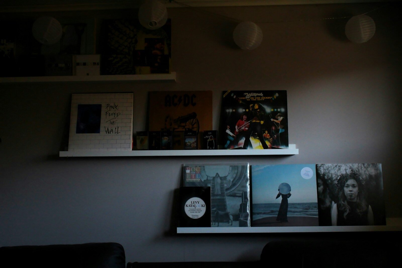 photos on white wall near black sofa