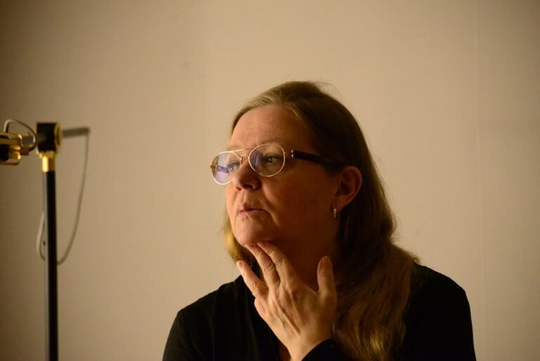 woman in black long sleeve shirt wearing eyeglasses